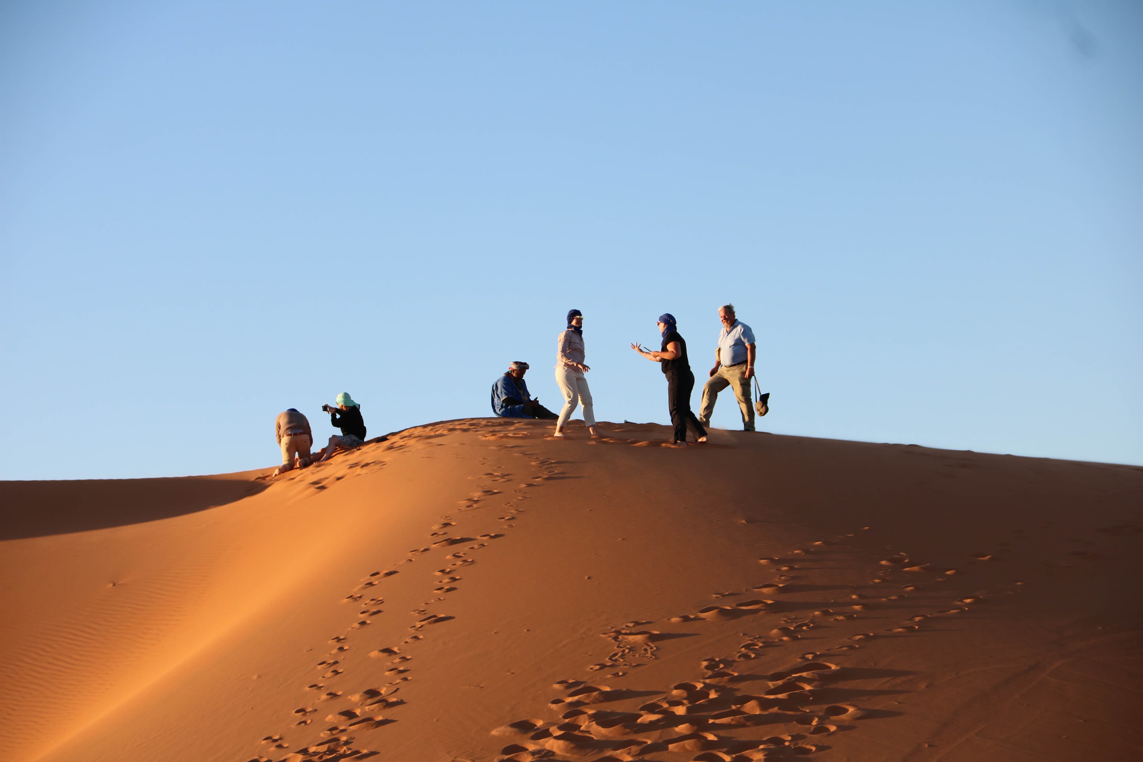 Travellers on a dune at golden hour, Erg Chebbi